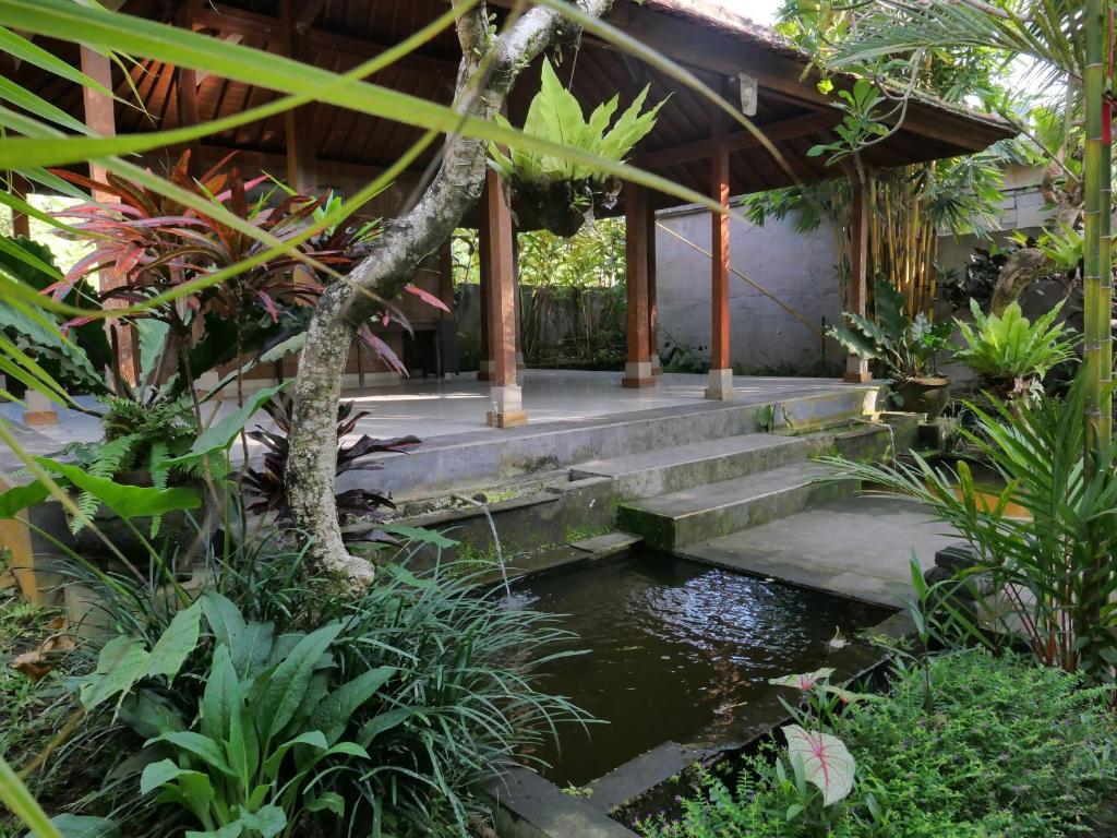 a house with a pond in the middle of a garden at Villa Mahayoni in Bedahulu