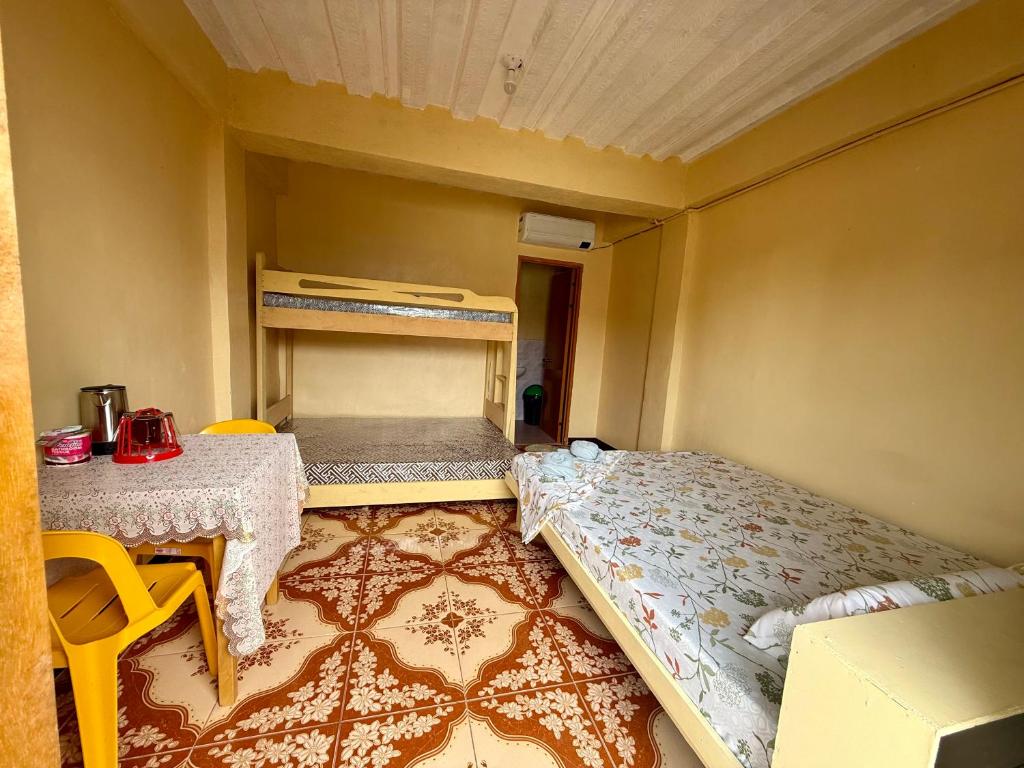 ein kleines Zimmer mit einem Bett und einem Tisch in der Unterkunft JJL pension house in Siquijor