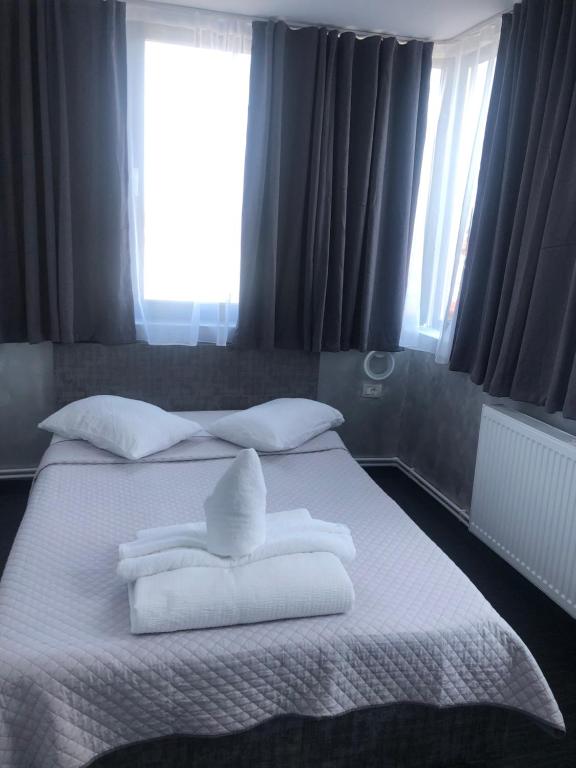 a bedroom with a bed with towels on it at Hotel Minion in Constanţa
