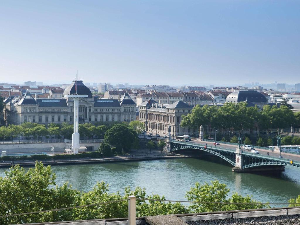 a city with a bridge over a river and buildings at Sofitel Lyon Bellecour in Lyon