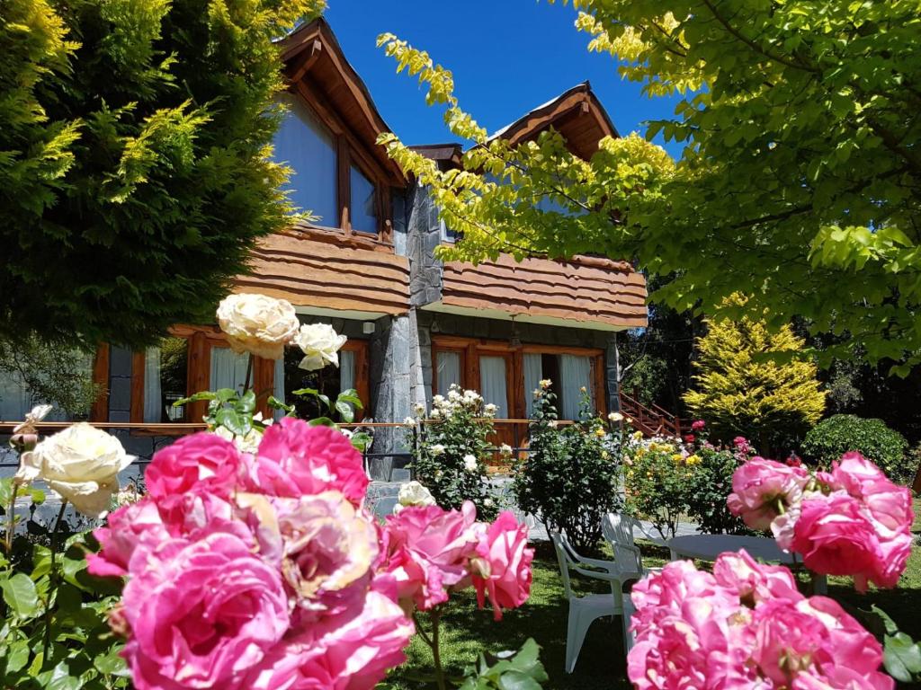 a house with pink roses in front of it at De las Rosas Bariloche in San Carlos de Bariloche