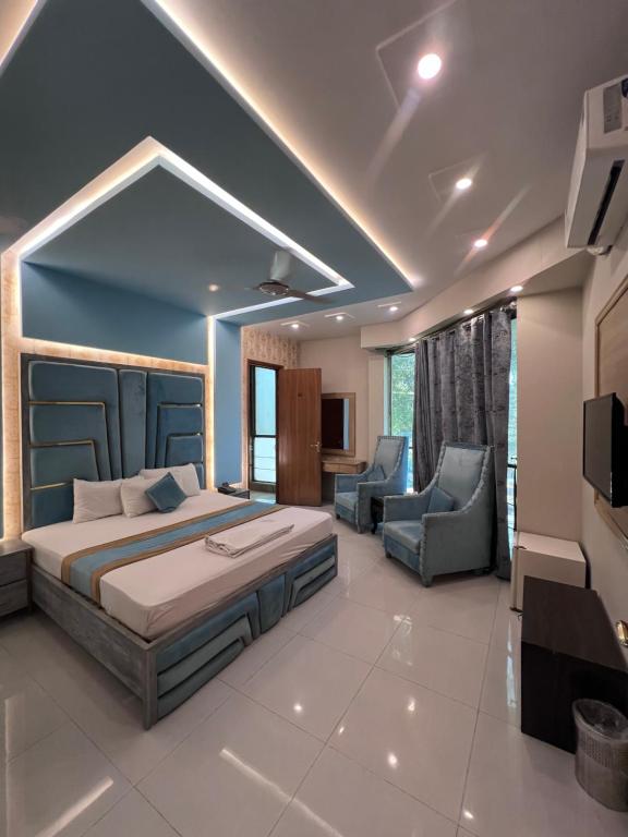 a bedroom with a bed and two chairs in it at Park View Hotel Gulberg in Lahore