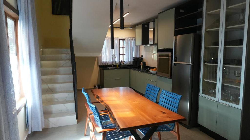 a kitchen with a wooden table and blue chairs at Loft Jeri Premium in Jericoacoara