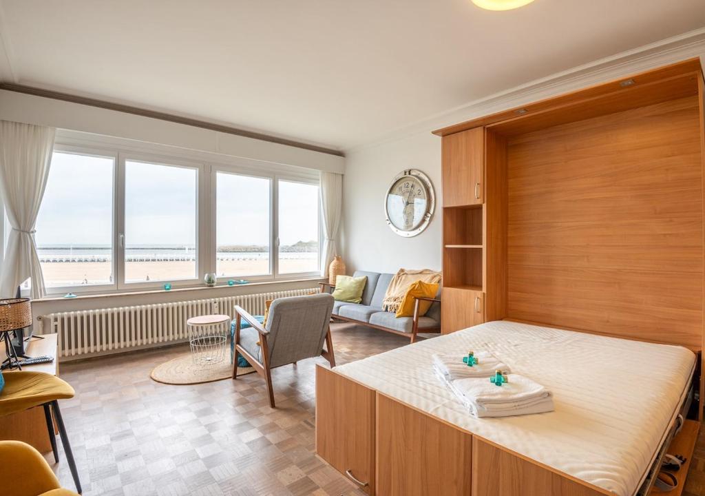a bedroom with a bed and a living room at Cozee in Ostend