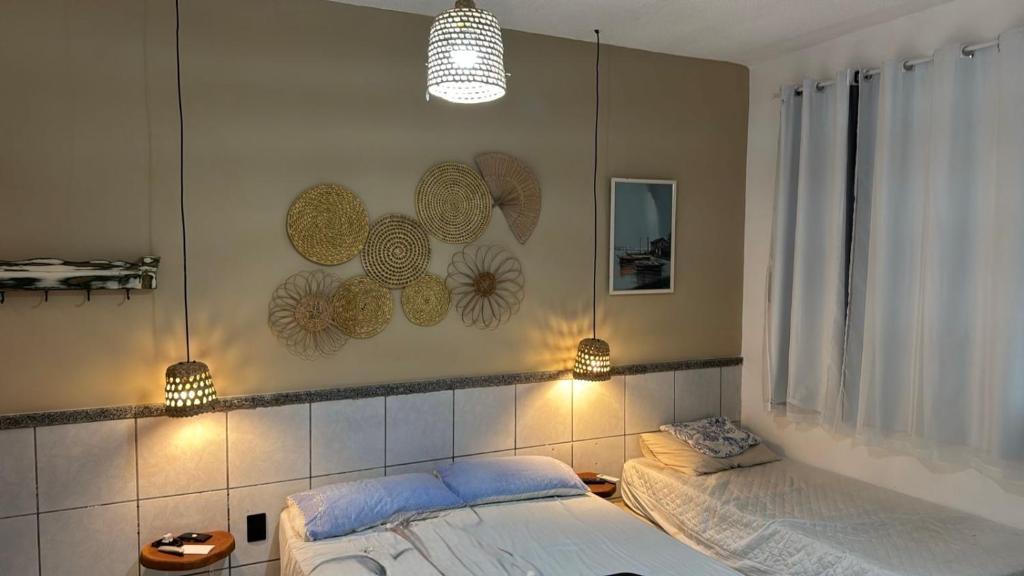 ein Schlafzimmer mit zwei Betten und zwei Lampen an der Wand in der Unterkunft Casa de Praia - Aracaju - Jatobá in Barra dos Coqueiros