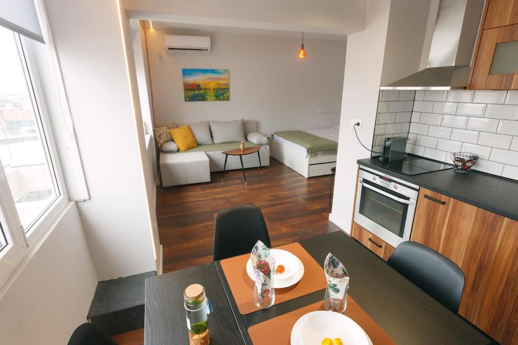 a kitchen and a living room with a table in a room at Serdica Tower View DT Parking Wi-Fi AC in Sofia