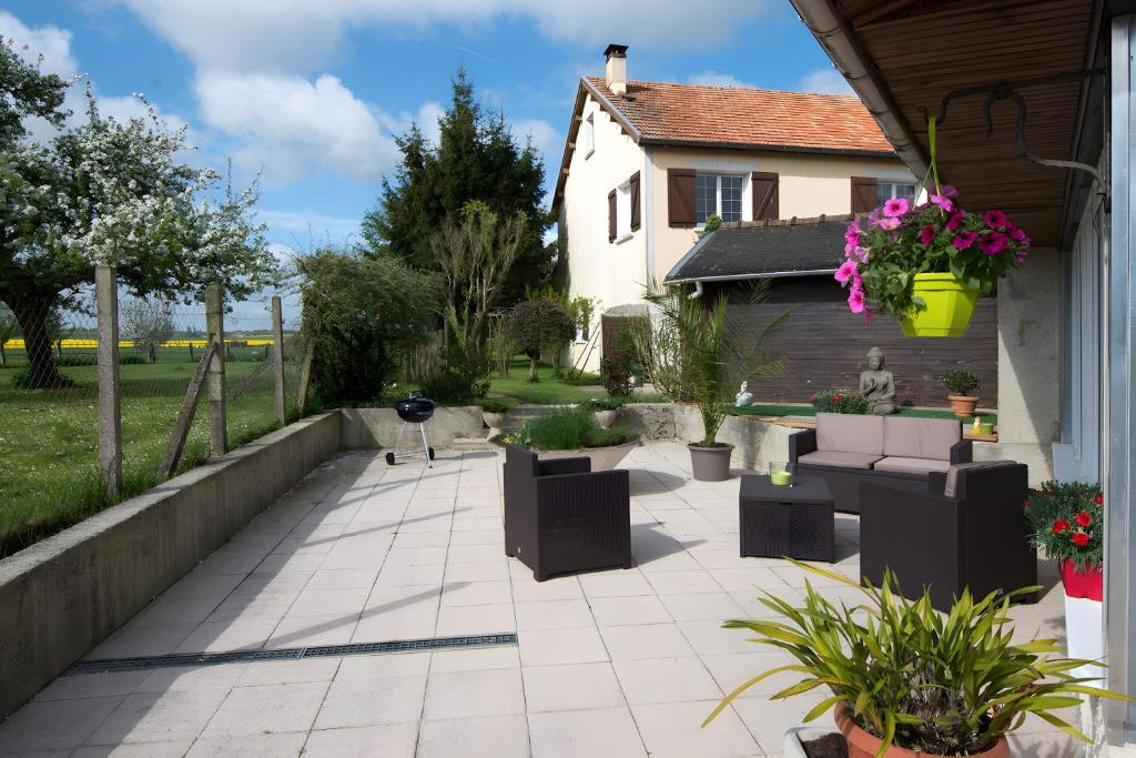 FromentièresにあるGîte Comme Chez Soi En Champagneのソファと植物と家のあるパティオ