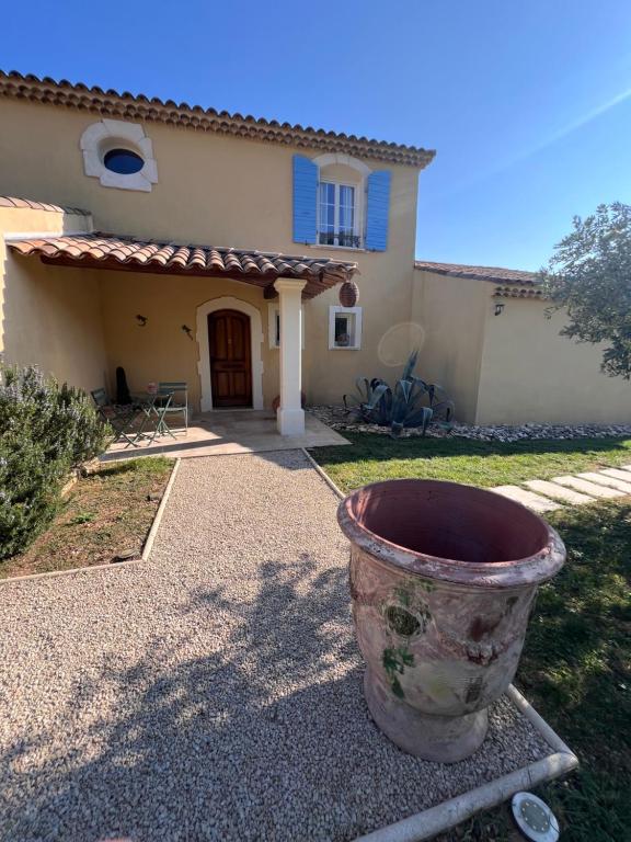 a large pot sitting in front of a house at La Bastide de Grosille in Savasse