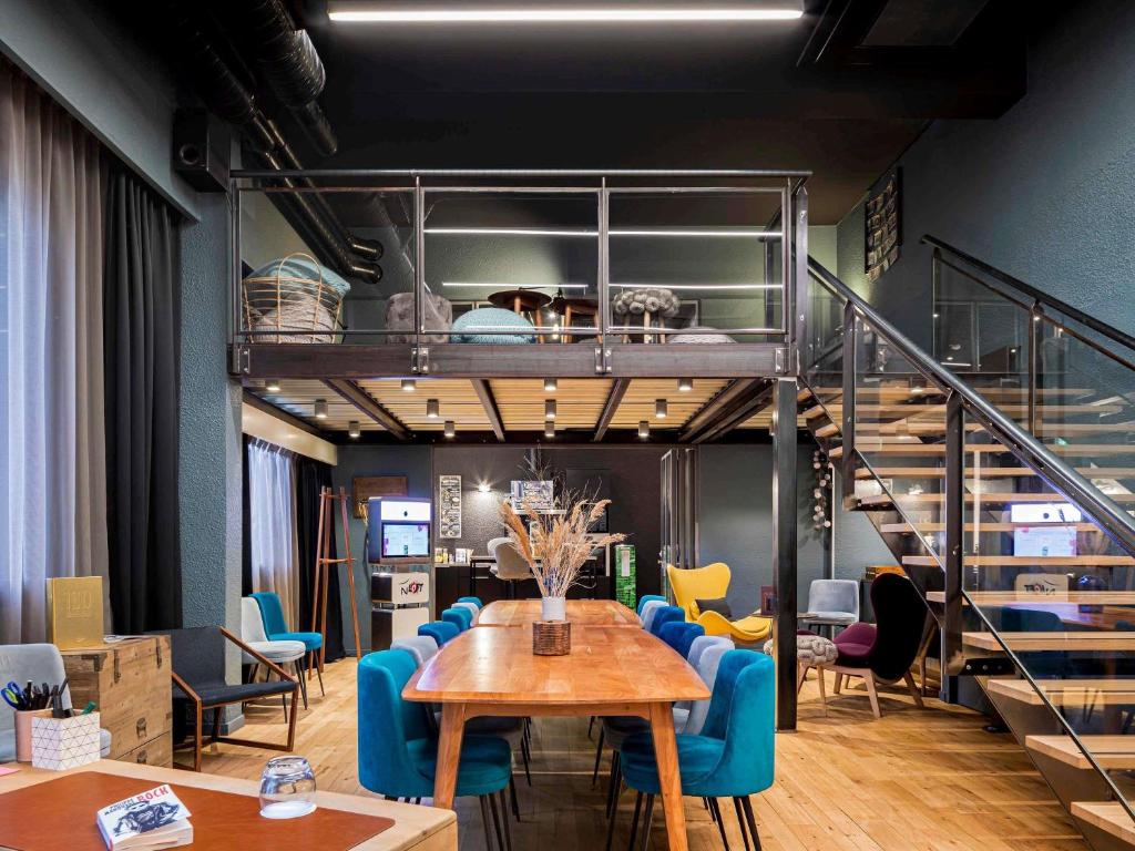 a room with a table and chairs and a staircase at Novotel Lyon Gerland Musée des Confluences in Lyon