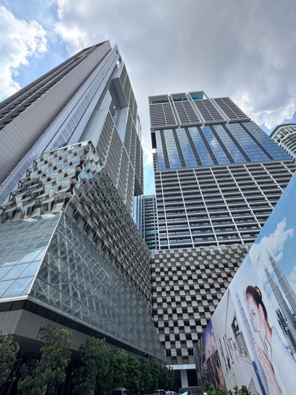 Un edificio alto con ventanas de vidrio en una ciudad. en PLATINUM SUITES KLCC By RAISA, en Kuala Lumpur