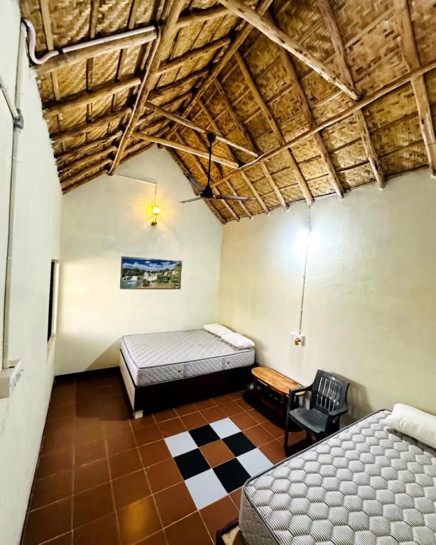 um quarto com uma cama e uma cadeira em um cômodo em Pawan Homestay Hampi em Hampi
