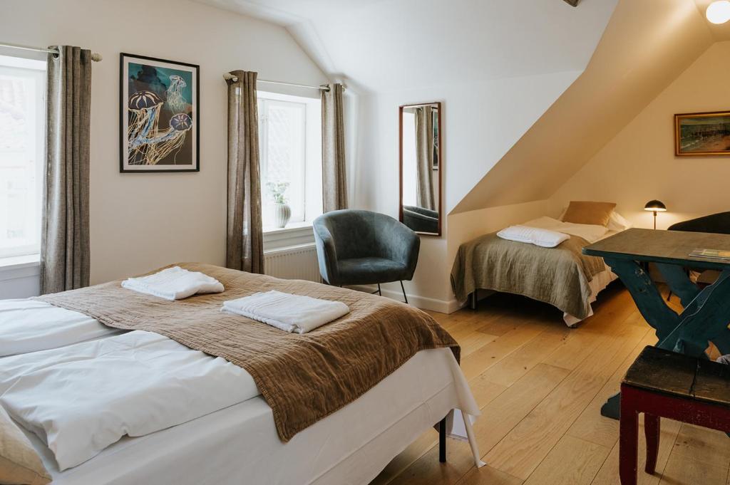a bedroom with two beds and a chair in it at KEFS Guesthouse & Café in Ærøskøbing