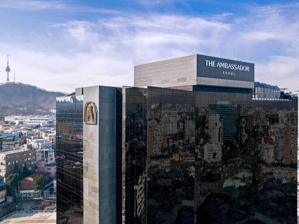 a large building with a sign on top of it at The Ambassador Seoul - A Pullman Hotel in Seoul