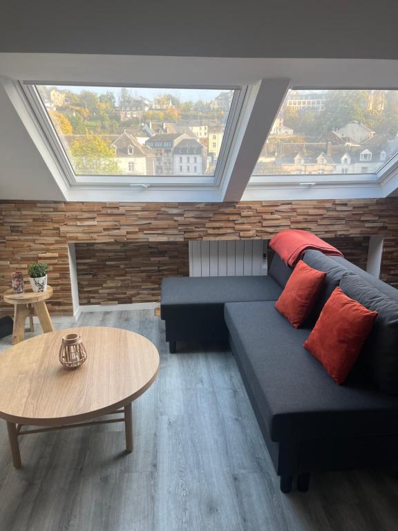 a living room with a couch and a table at Le refuge du Cerf in Bouillon