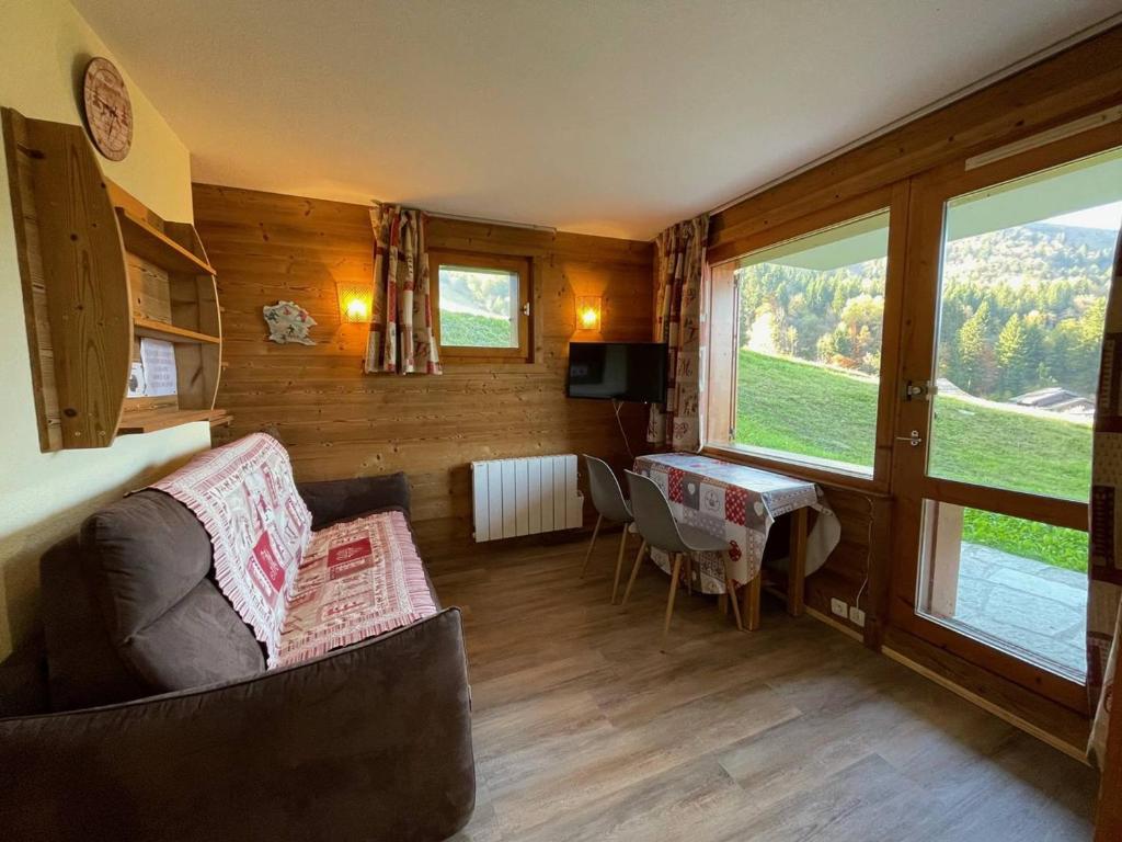 a living room with a couch and a table at Appart 4 pers, accès direct pistes, terrasse, 50m remontées - FR-1-356-426 in Valmorel