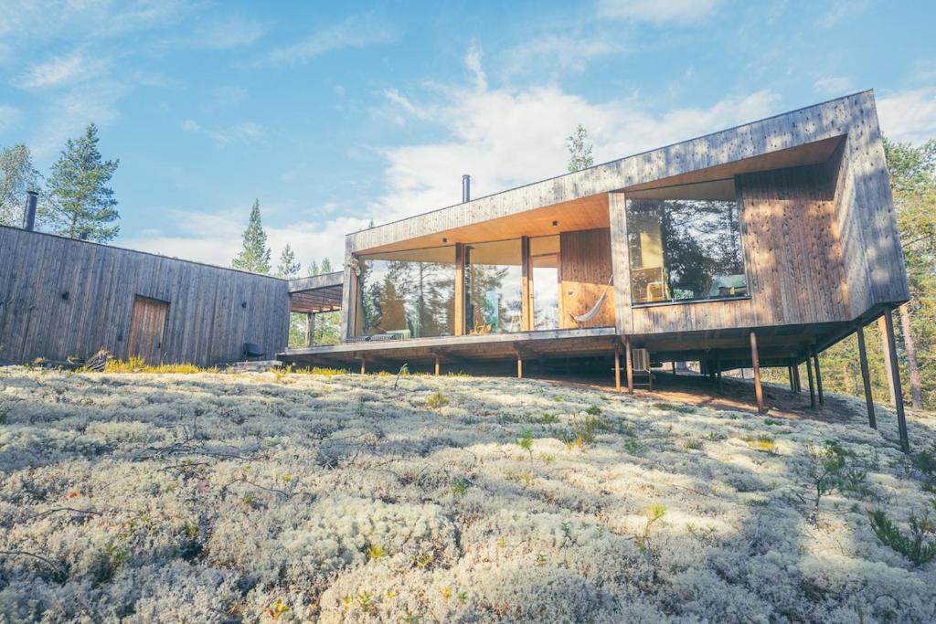 a modern house on a grassy field at Hideout Villa Jäkälä in Rokua