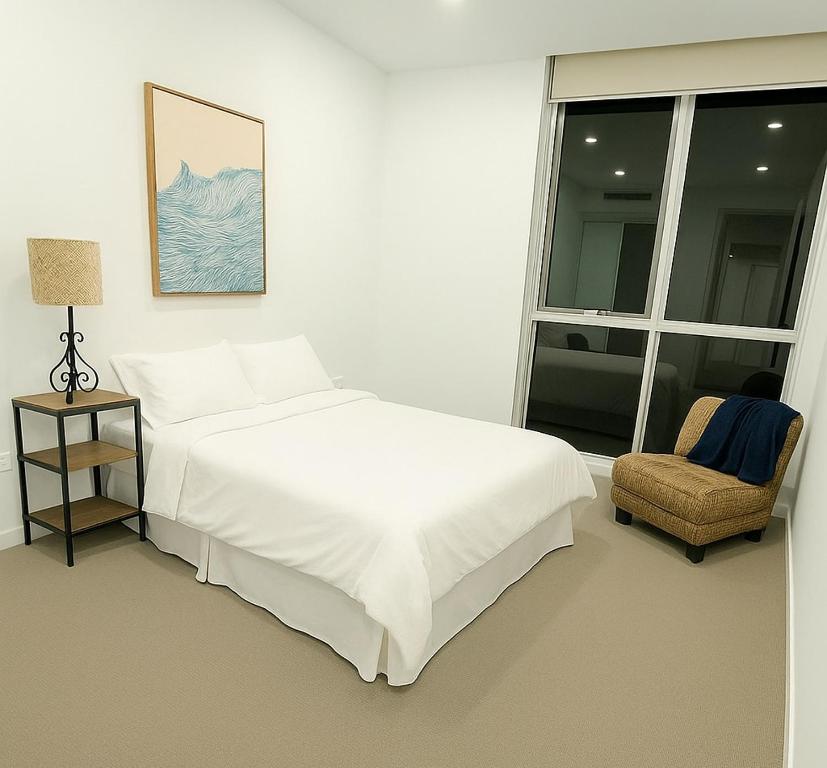 une chambre avec un lit, une chaise et une fenêtre dans l'établissement Cozy Suite in Schofields, à Schofields