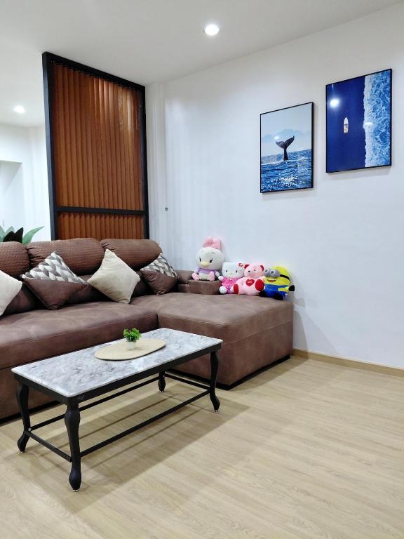 a living room with a couch and a coffee table at Litha Homestay HatYai in Sathani Khlong Rian