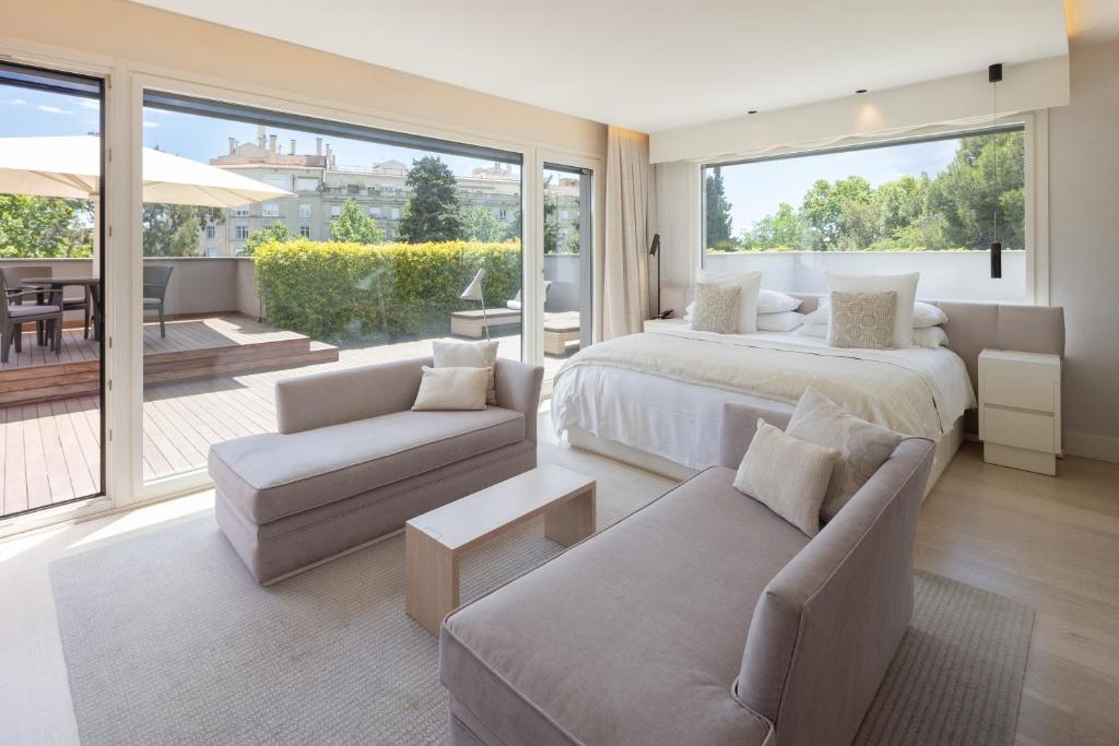 a large bedroom with two beds and a balcony at ABaC Restaurant Hotel Barcelona GL Monumento in Barcelona