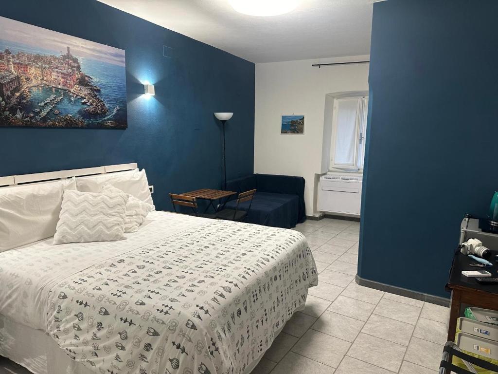 a bedroom with a bed and a blue wall at Ca Du Grifun 2 in Vernazza