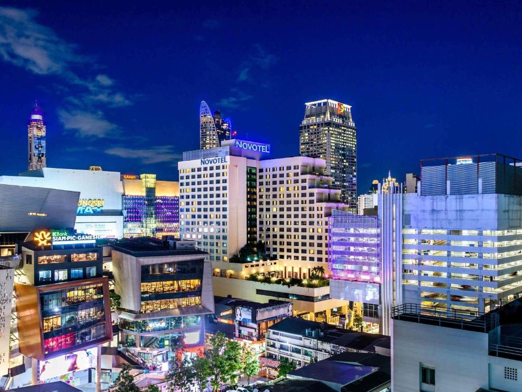a city skyline at night with many tall buildings at Novotel Bangkok on Siam Square in Bangkok