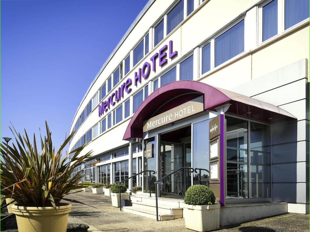 un bâtiment avec une enseigne sur la façade dans l'établissement Mercure Saint Lô Centre, à Saint Lo