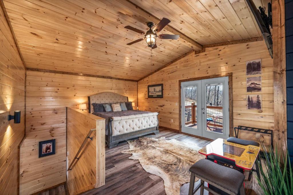 a bedroom in a log cabin with a bed and a ceiling fan at Luxury Cabin with Hot Tub and Resort Access in Sevierville