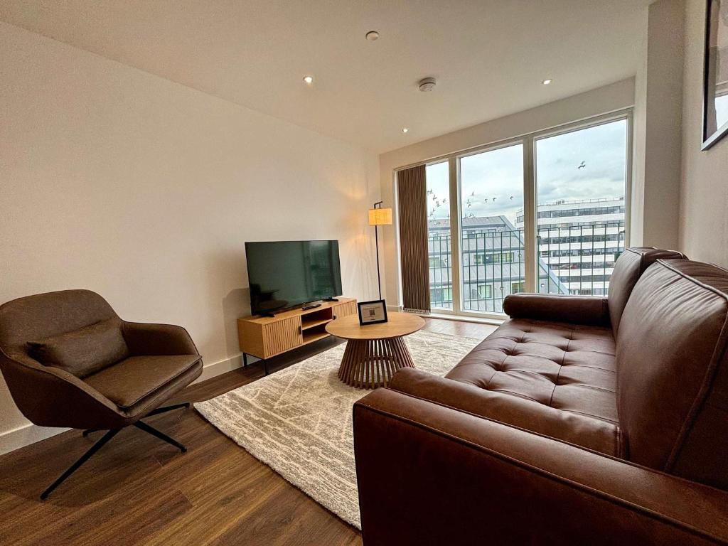 a living room with a couch and a chair and a television at Luxury 2 bed Apt Near Ascot & Windsor in Bracknell