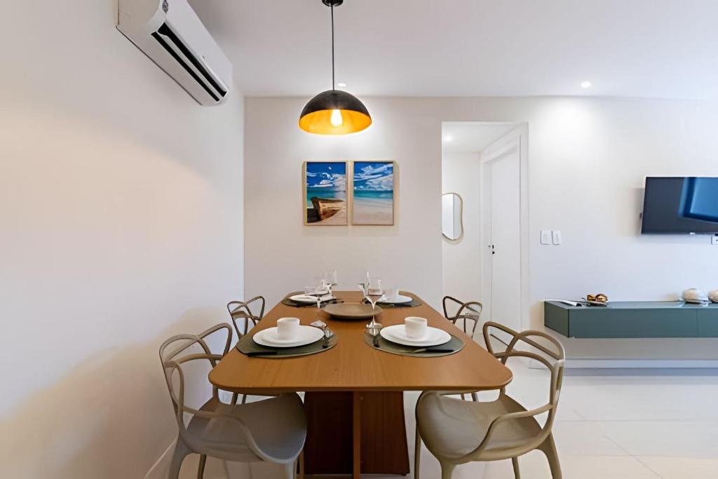 a dining room with a wooden table and chairs at Edifício Mosaico do Mar - Seu Refugio na Praia da Jatiúca in Maceió