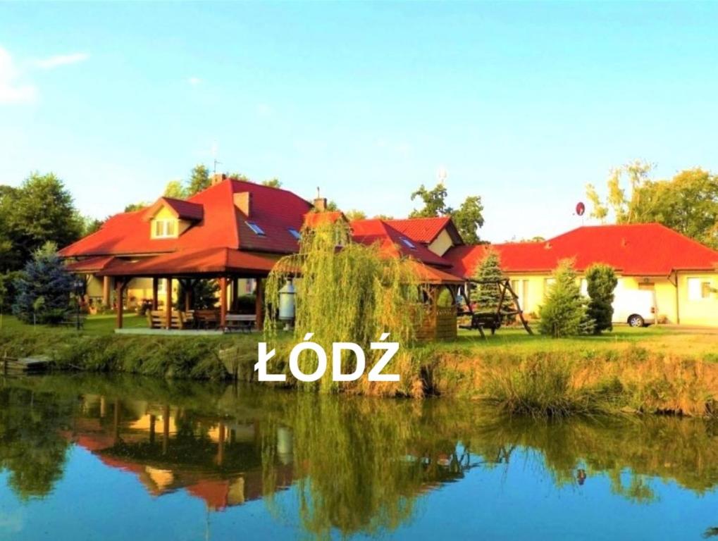 ein Haus mit dem Wort Lodz vor einem See in der Unterkunft ŁÓDZKI DOM TURYSTYCZNY-ŁÓDŹ Helenówek-Pokoje z łazienkami,F-VAT, DLA NIEPALĄCYCH, Parking gratis tylko auta osobowe in Łódź