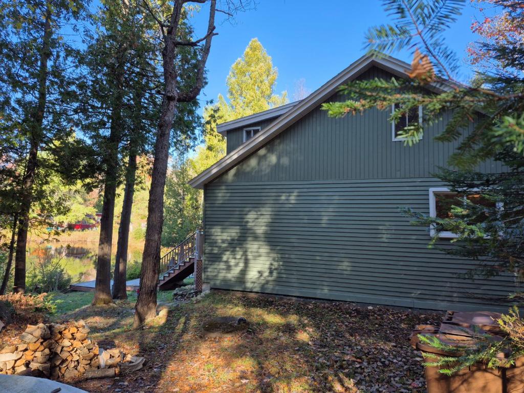 a house with a garage in the woods at Chalet lac Chantelle in Chertsey