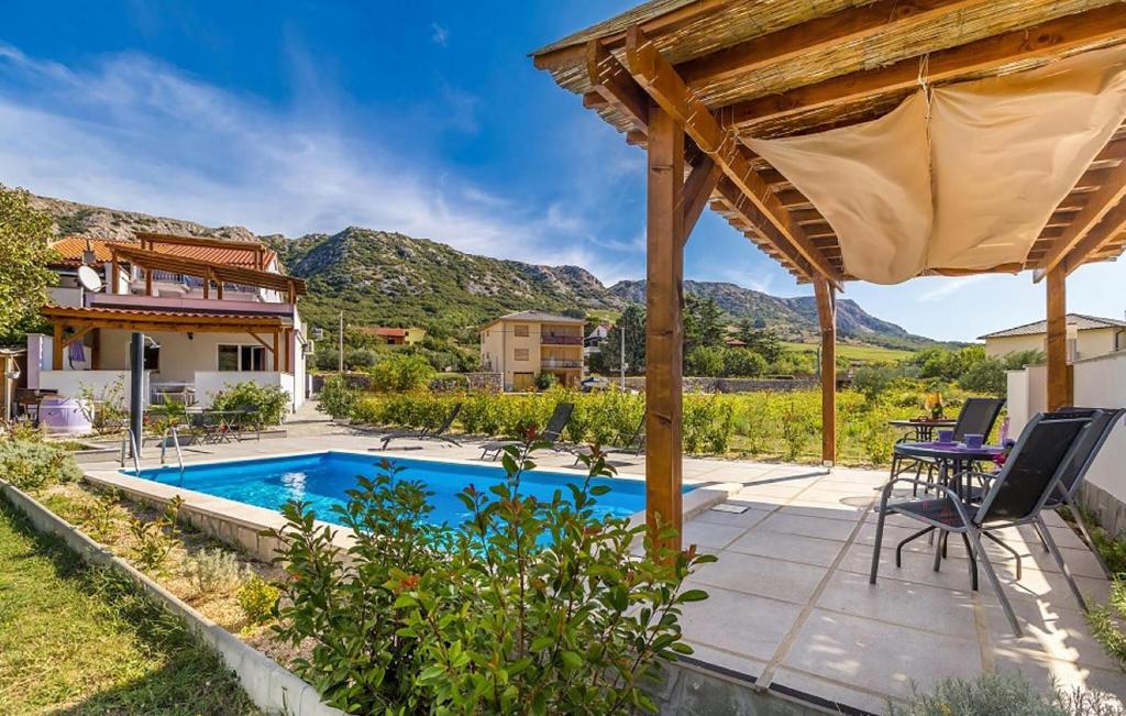 Draga BašćanskaにあるCozy Apartment In Baska With Swimming Poolのスイミングプールとパーゴラ付きの家