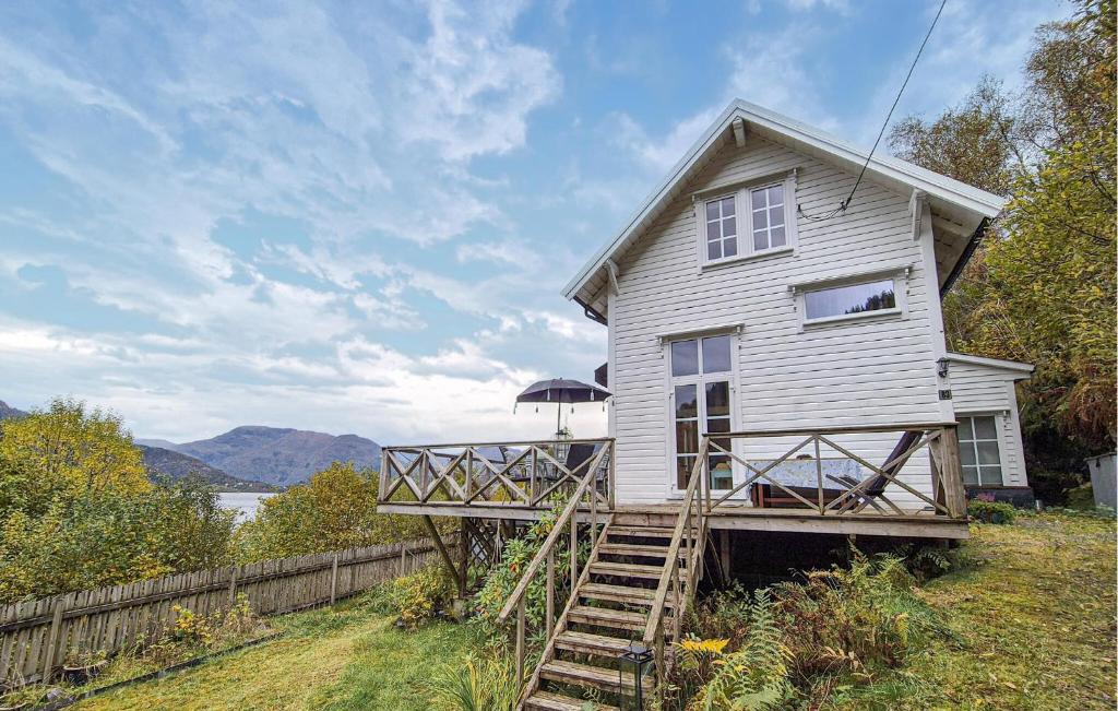 a white house with a staircase leading up to it at Beach Front Home In Vaksdal With House Sea View in Stavenesli