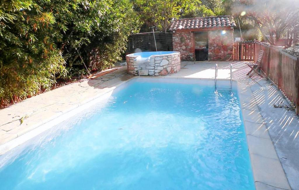 une grande piscine bleue dans une cour arrière dans l'établissement Gorgeous Home In Les Mages, à Les Mages