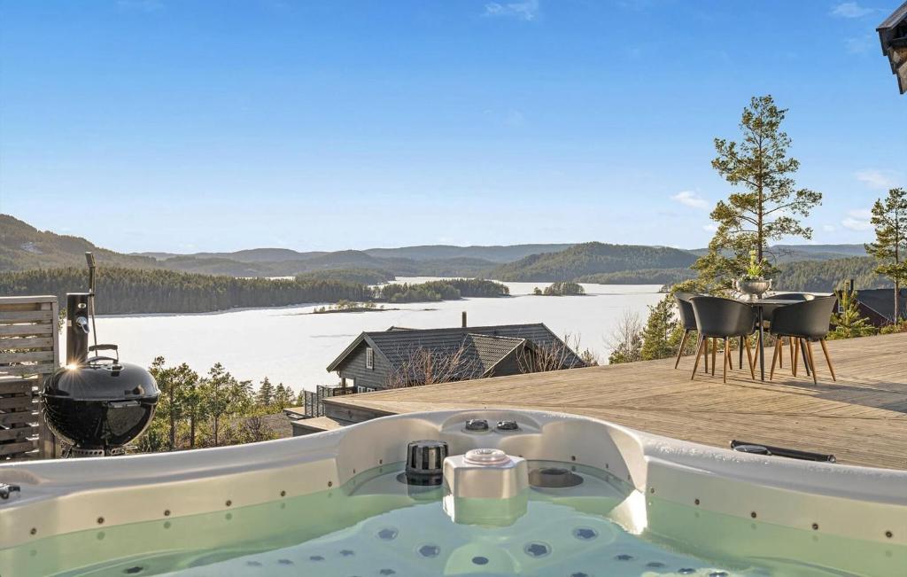 a bath tub on a deck with a view of a lake at Beautiful Home In Sannidal With Lake View in Neslandsvatn