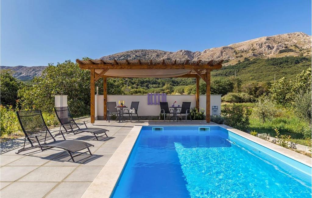 a swimming pool with chairs and a gazebo at Cozy Apartment In Baska With Swimming Pool in Draga Bašćanska
