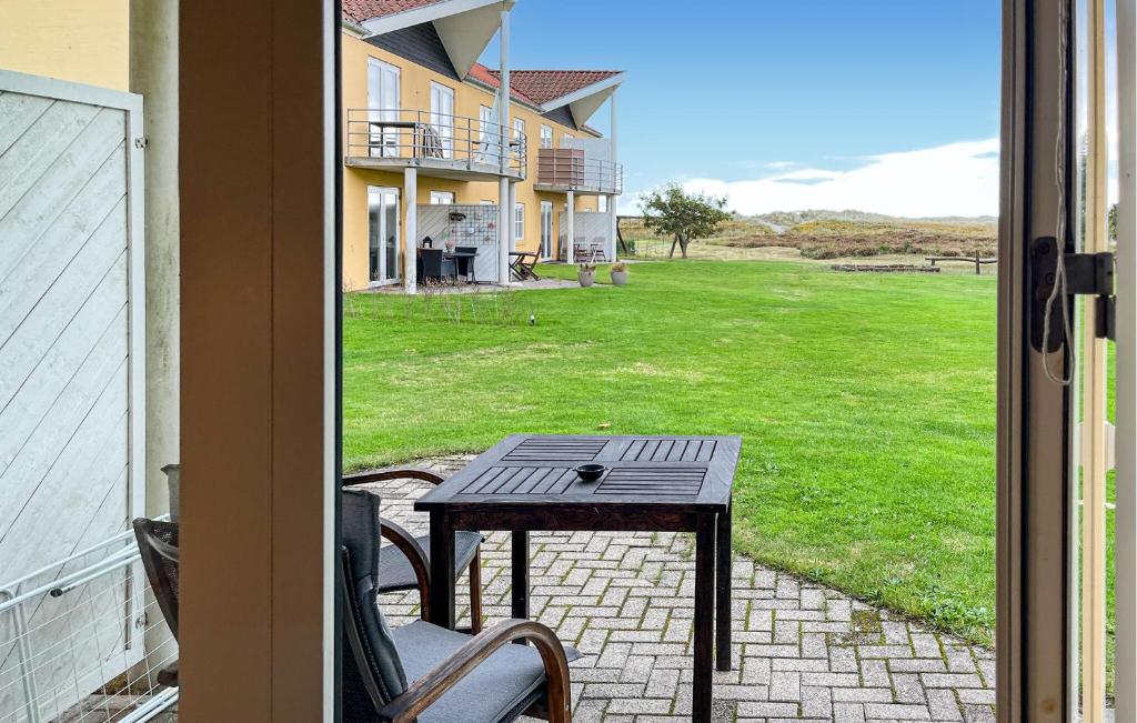 a patio with a table and chairs on a porch at Awesome Apartment In Hals With House A Panoramic View in Skovsgård