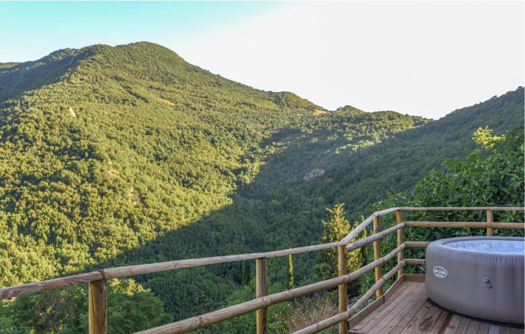 a hot tub on a wooden deck with mountains in the background at Lovely Home In Castelletta in Precicchie