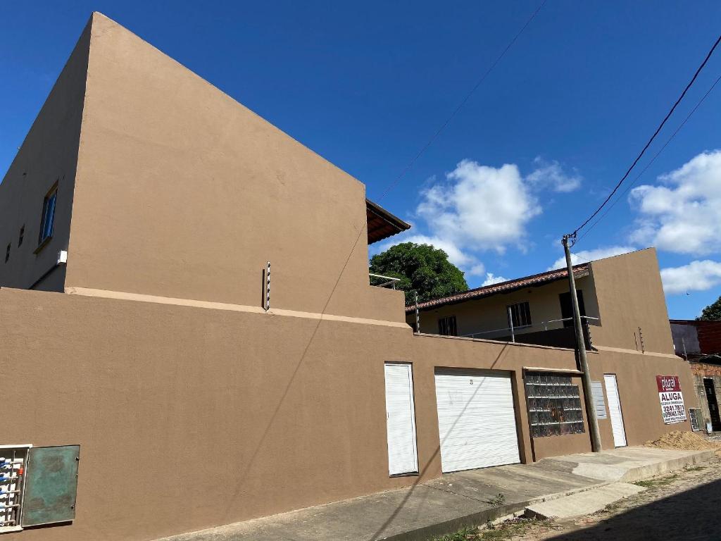a brown building with white doors on the side of it at Apartamento acolhedor Maracanaú -Premium in Maracanaú