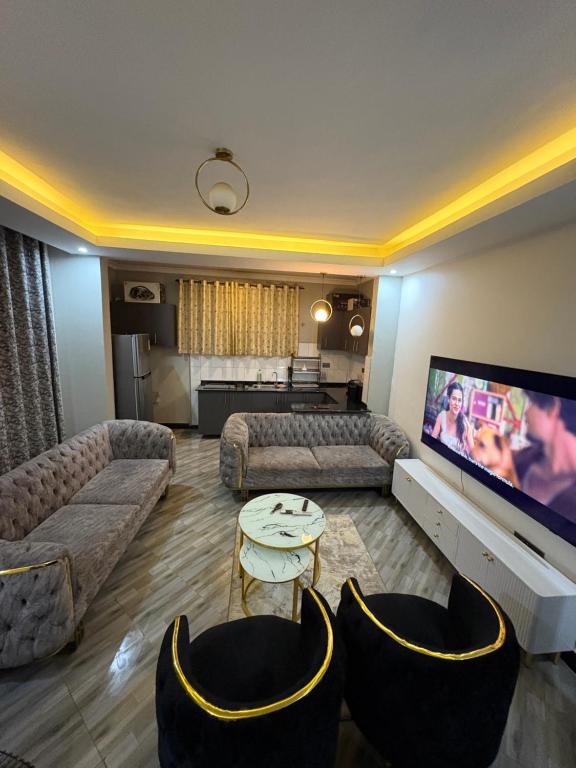 a living room with couches and a flat screen tv at Trustbridge in Kampala