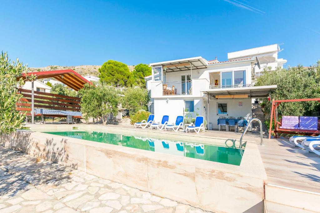 a villa with a swimming pool and a house at House Osti in Rogoznica