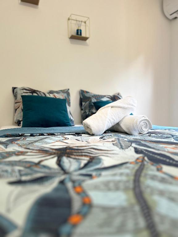 a bed with a blanket and pillows on it at Maison traditionnelle proche Malendure in Bouillante