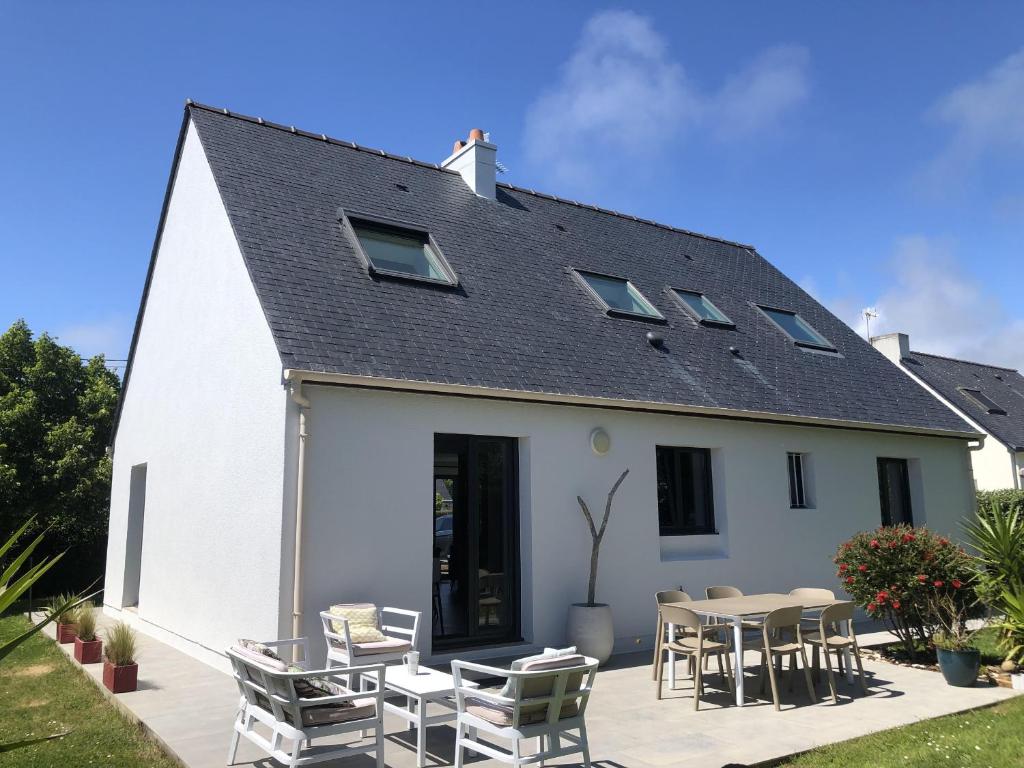 una casa blanca con sillas y una mesa en 500m des plages - Vacances à 6 autour du Golfe, en Saint-Gildas-de-Rhuys