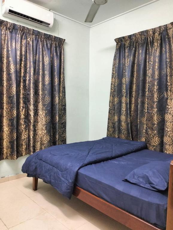 a bedroom with a blue bed in front of a window at Homestay Teratak Senja in Pasir Mas