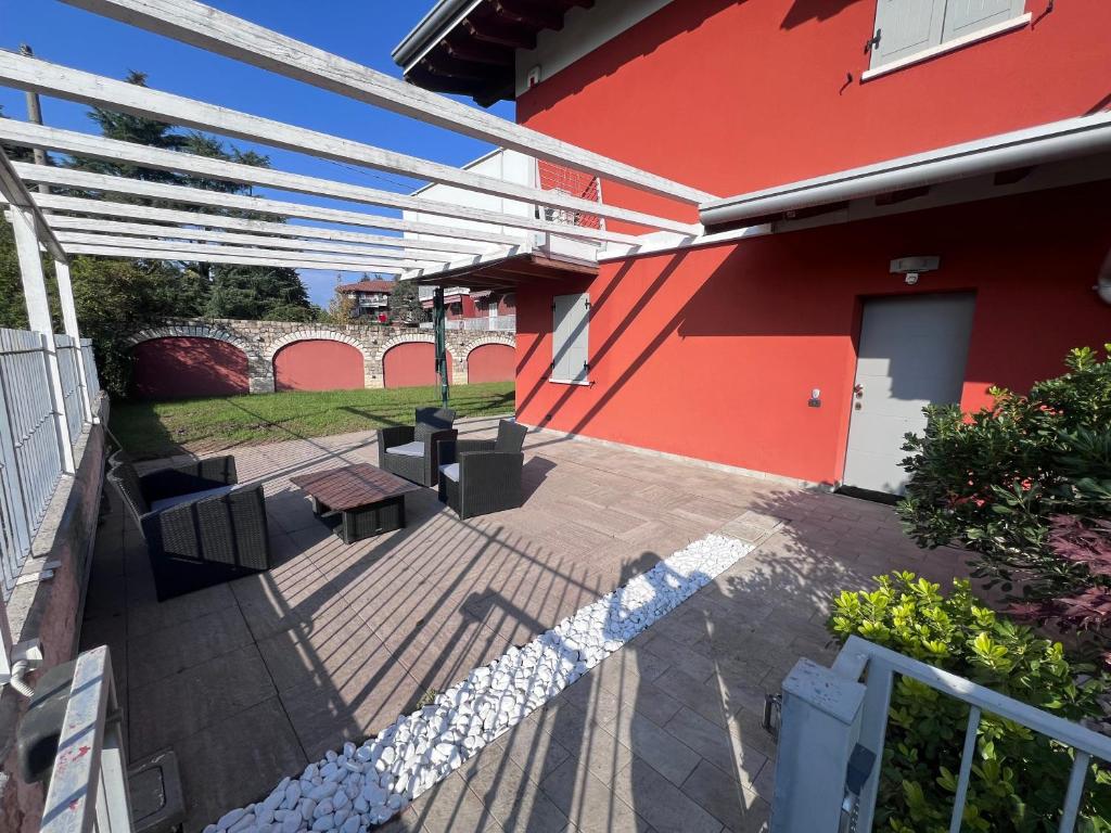 a patio of a red house with a table and a bench at B2In Suite & Office in Capriate San Gervasio