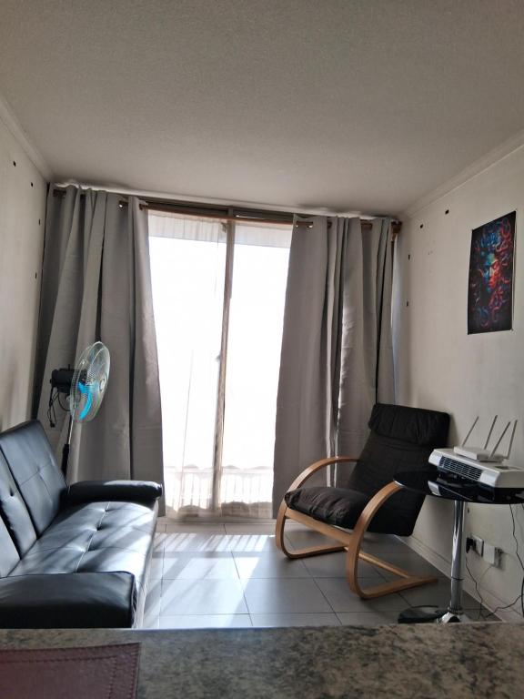 una sala de estar con un sofá y una mesa en Departamento Parque O'Higgins, en Santiago