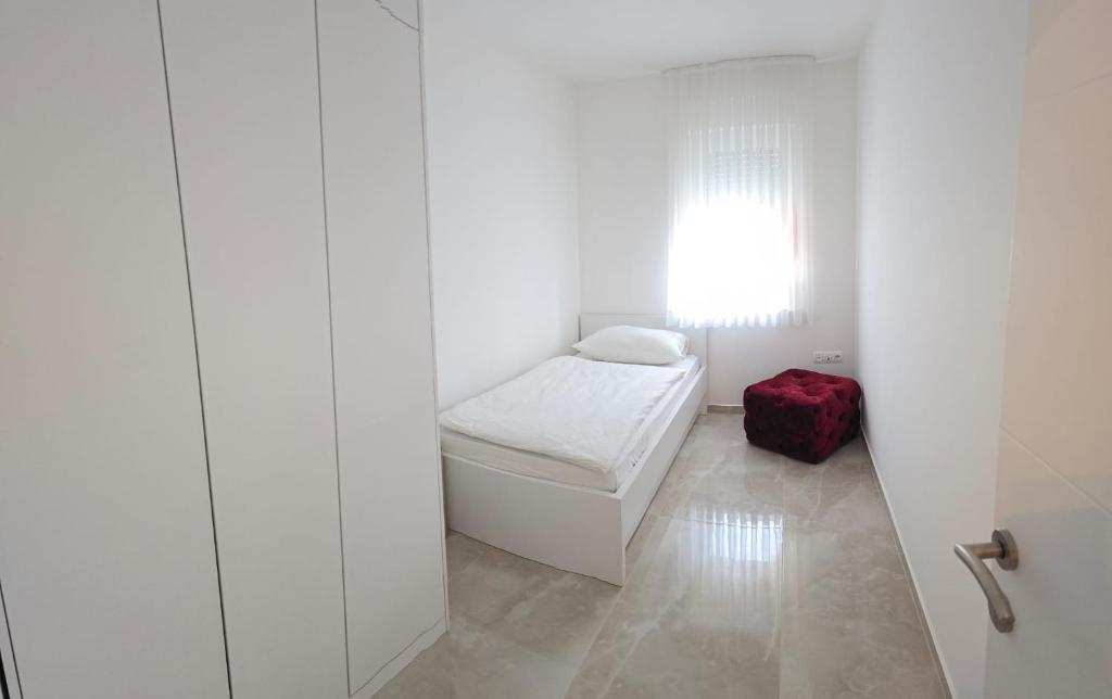 a small white room with a small bed and a window at Apartman City Pearl in Posušje