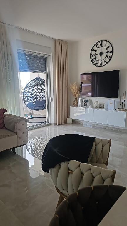 a living room with a couch and a tv at Apartman City Pearl in Posušje