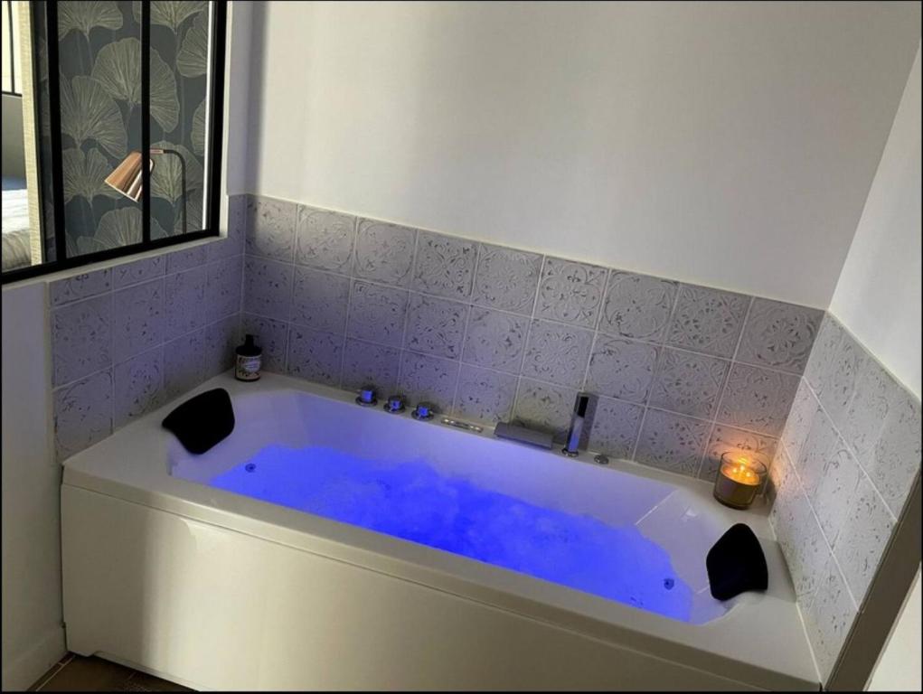 a blue tub in a bathroom with a candle at Charmant Studio Balneo wifi clim borne electrique in Vierzon