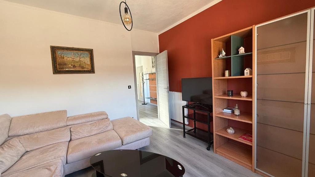 a living room with a couch and a tv at Centro Città 2 in Gorizia